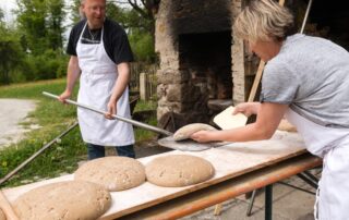 Bäckerin und Bäcker backen frisches Brot auf der „GutsAlm Harlachberg“